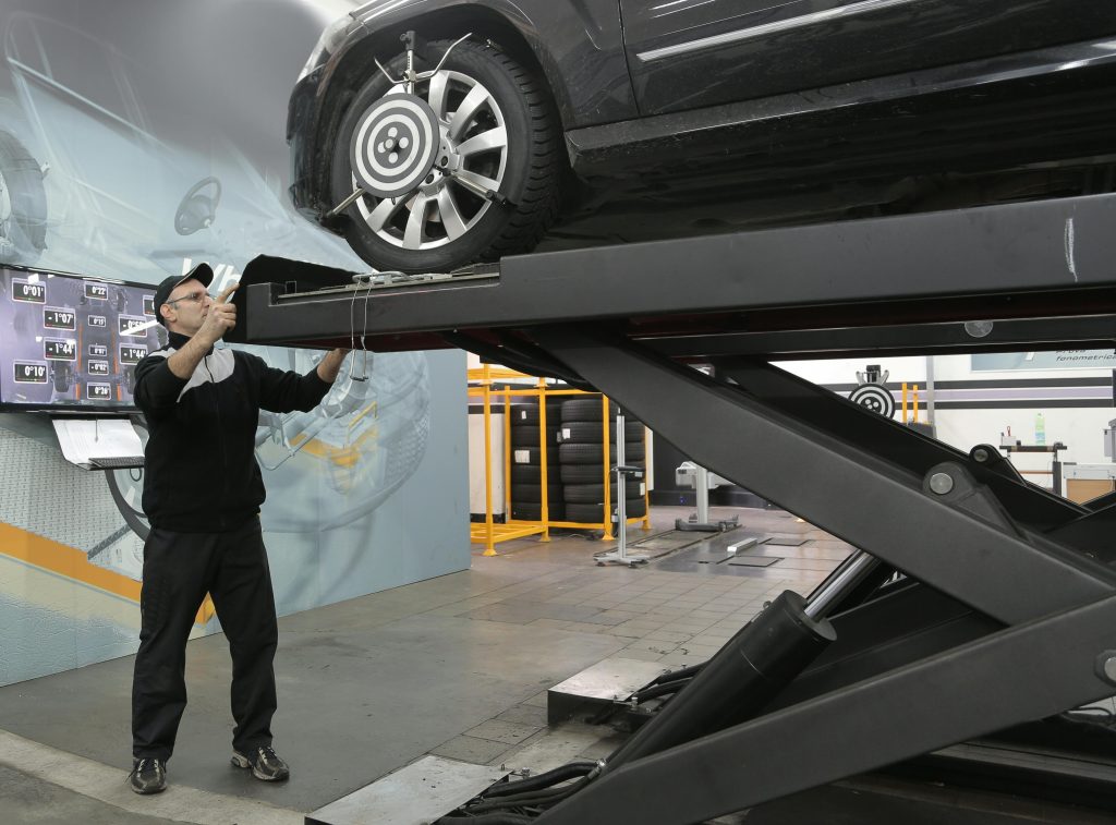 Costos-de-arreglar-un-coche-siniestrado Tecnico revisando coche nuevo comprado