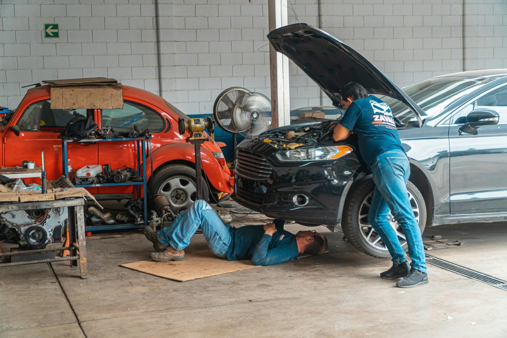 Es-posible-arreglar-un-coche-totalmente-siniestrado2 Dos mecánicos arreglando un coche.