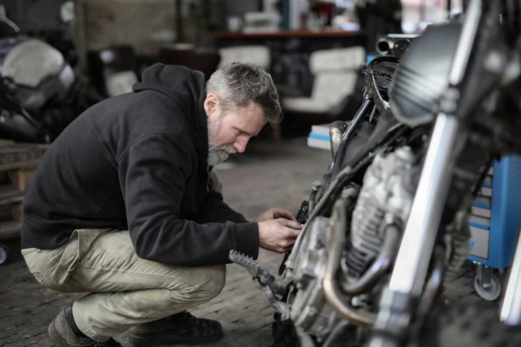 Merece-la-pena-arreglar-un-coche-declarado-siniestro Hombre reparando una moto que había sido declarada siniestro total