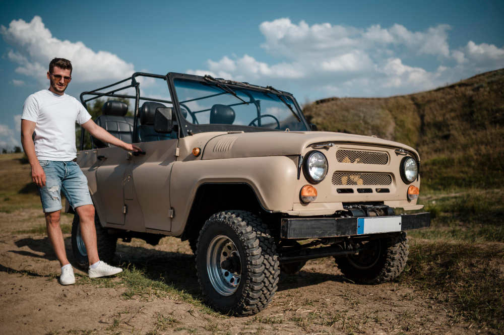 Un chico al lado de su vehículo 4x4 homologado y preparado para off road, el cual está en venta.