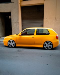 Volkswagen Golf III amarillo, vista lateral, stance bajo, carrocería alisada, llantas grandes