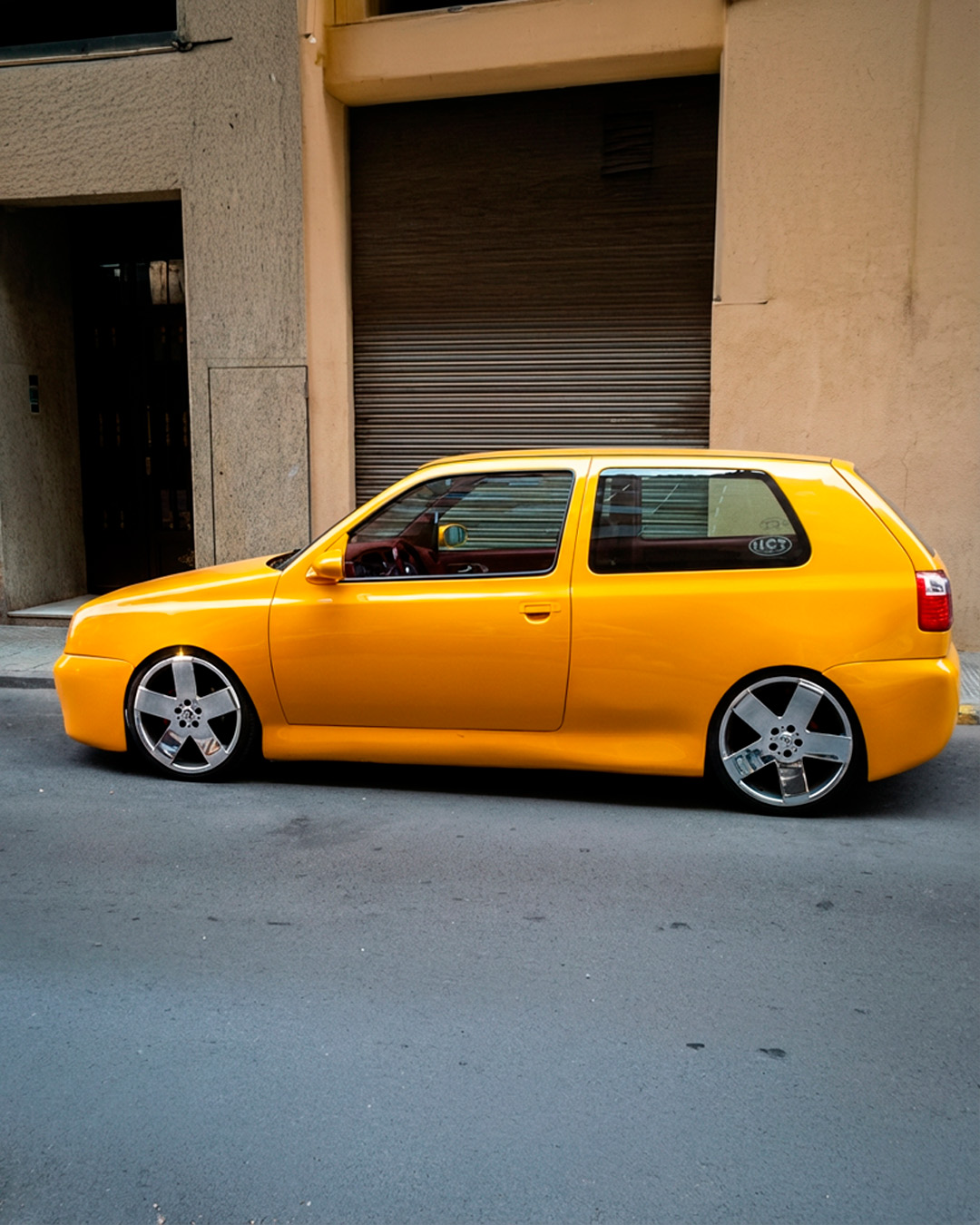 Volkswagen Golf III amarillo, vista lateral, stance bajo, carrocería alisada, llantas grandes